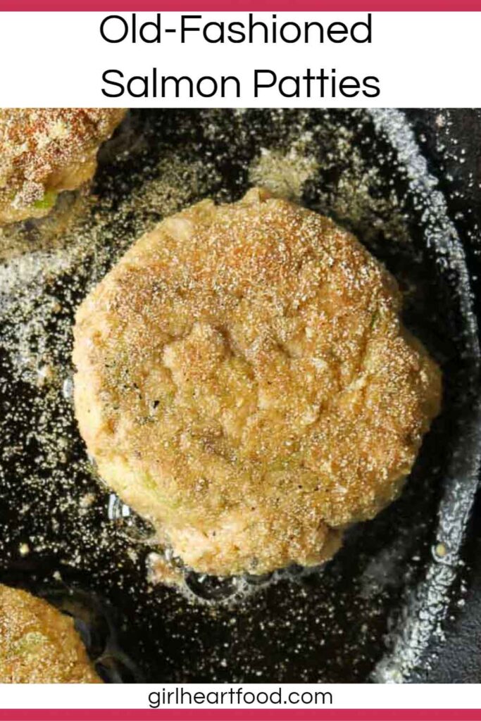 Close-up of a salmon patty frying in a cast-iron pan.