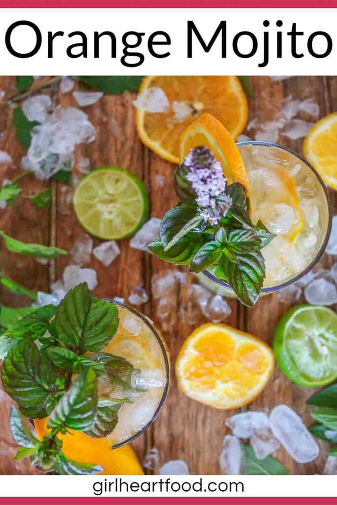 Two glasses of orange mojito, each garnished with mint and a slice of orange.