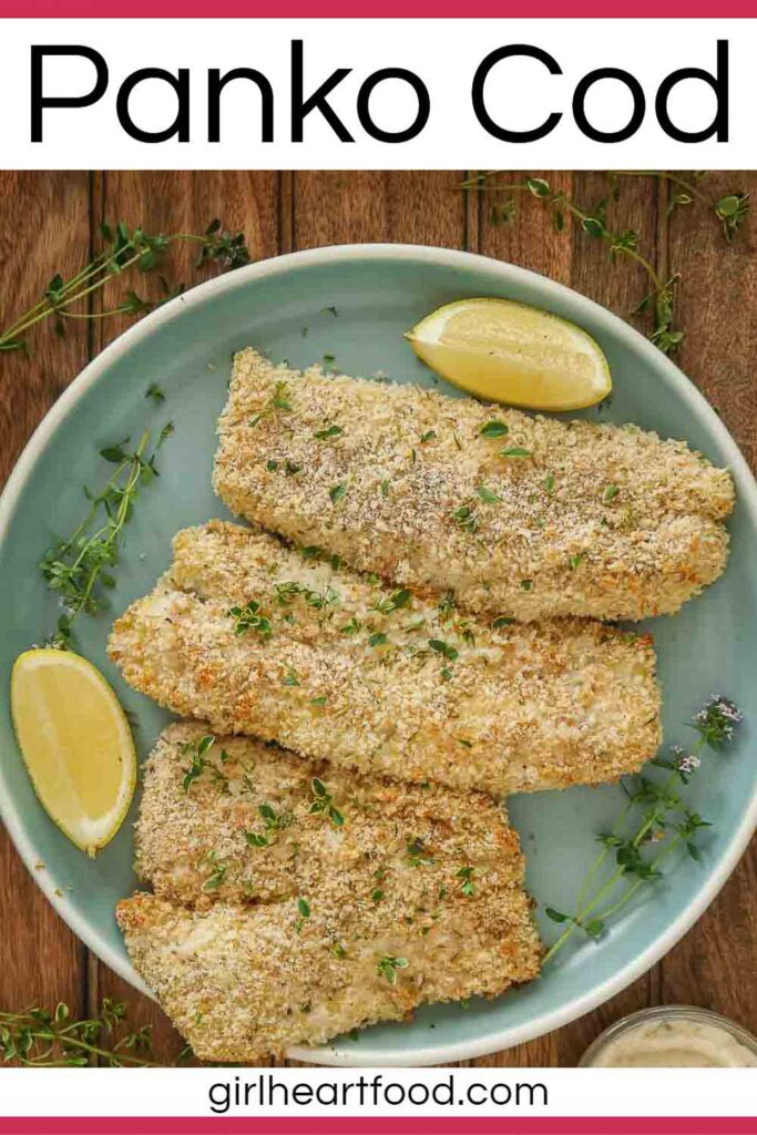 Three panko-crusted cod fillets with thyme and lemon wedges on a blue plate.