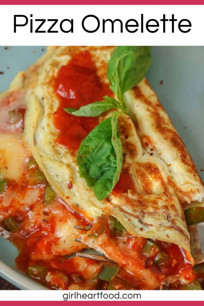 Close-up of a pizza omelette garnished with fresh basil on a blue plate.