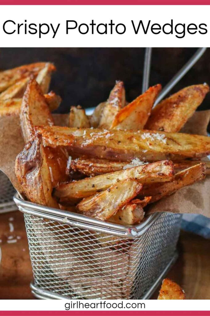 Crispy potato wedges in a stainless steel basket.