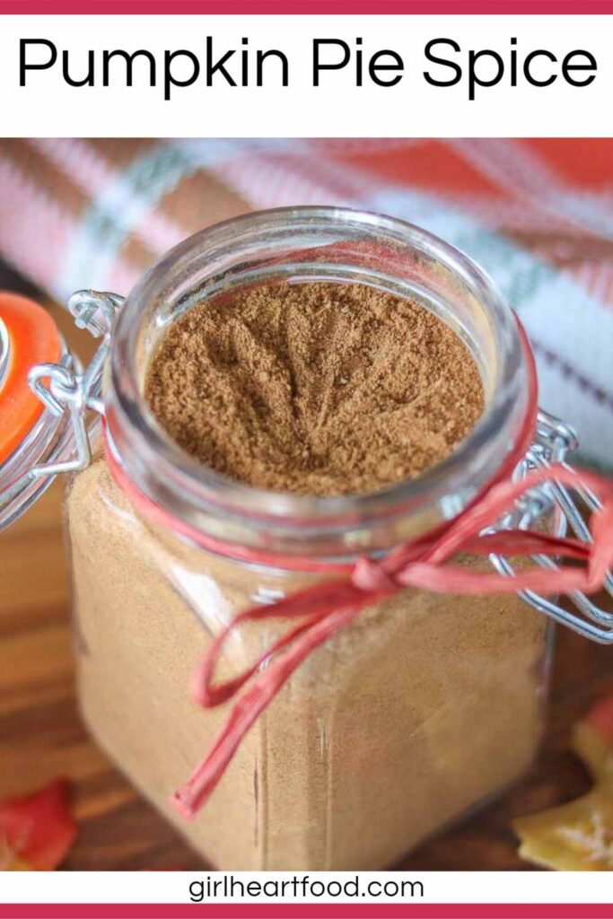 Jar of homemade pumpkin pie spice with a ribbon tied around it.