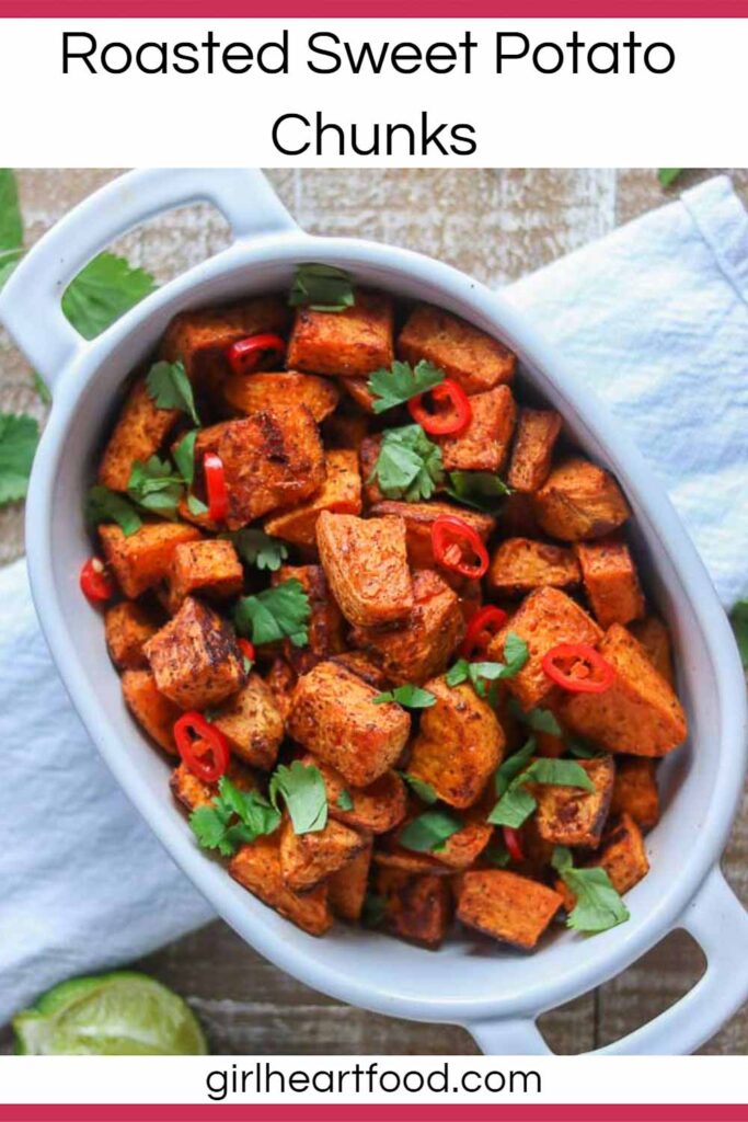 Roasted sweet potato chunks in a dish garnished with cilantro and chili pepper.