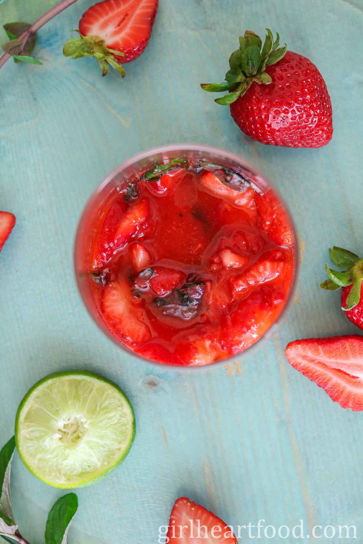 Muddled strawberries and mint in a glass.