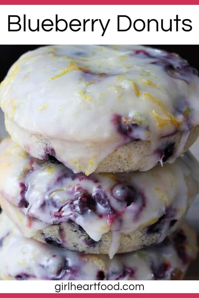 Close-up of a stack of three baked blueberry donuts with lemon glaze.