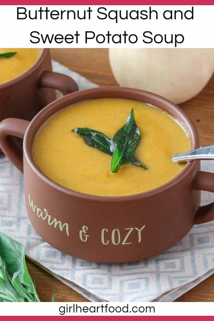Bowl of creamy butternut squash sweet potato soup with sage leaves on top.