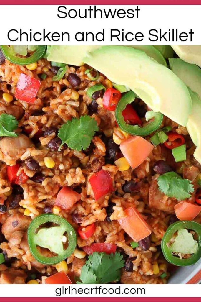 Close-up of chicken and rice in a dish garnished with avocado, jalapeno, cilantro and tomatoes.