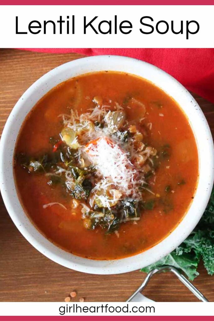 Bowl of lentil and kale soup garnished with grated Parmesan cheese.