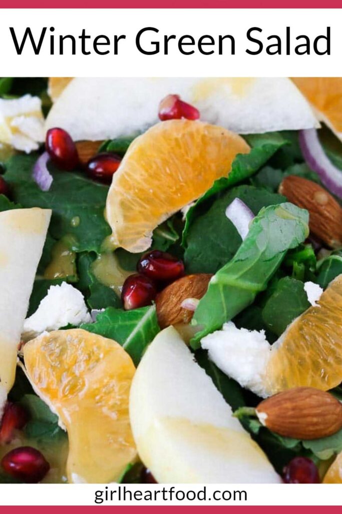 Close-up of a winter green salad with fruit, drizzled with honey Dijon vinaigrette.