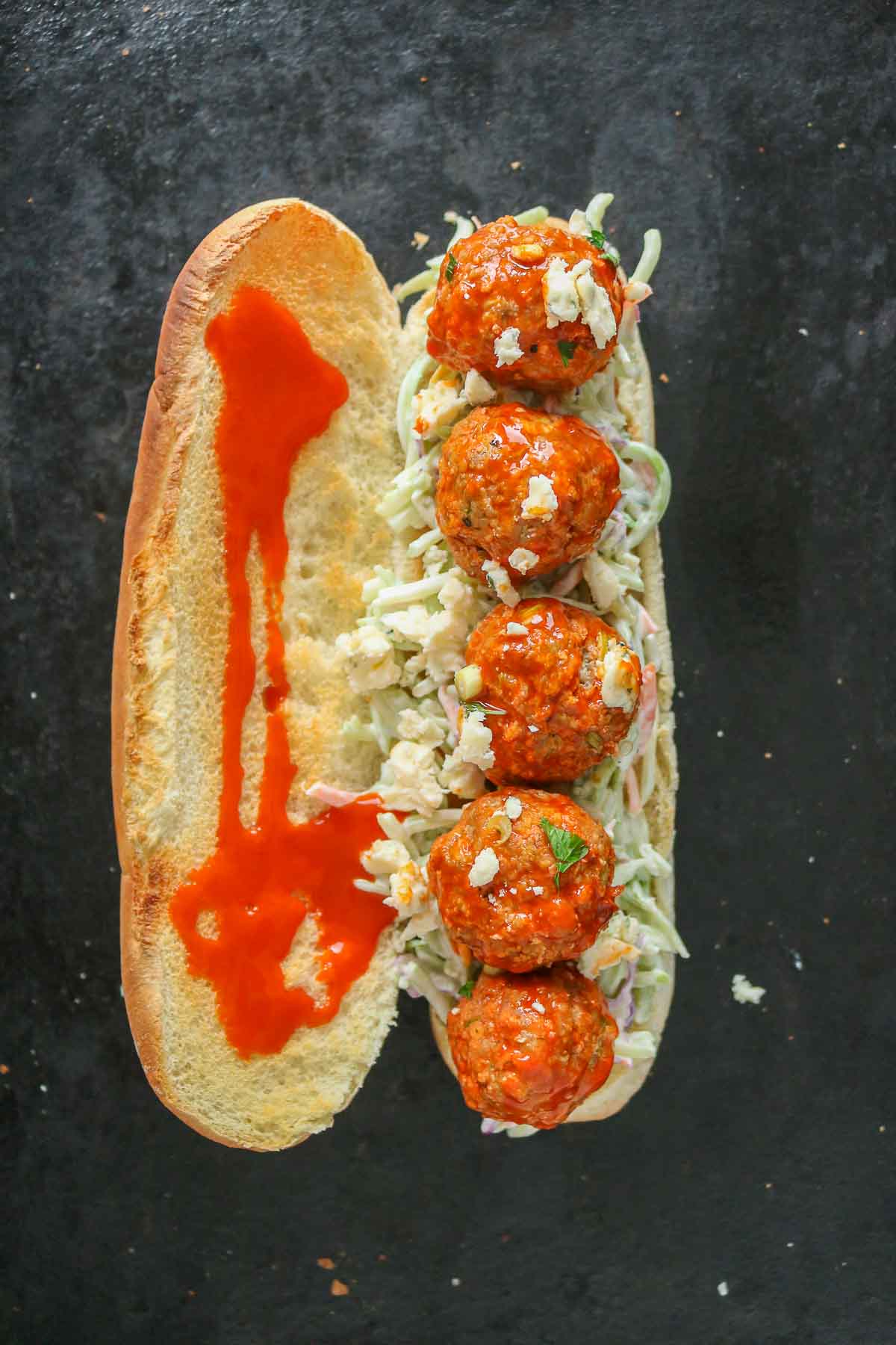 Spicy sub sandwich with buffalo turkey meatballs before the top bun is placed over the bottom bun.