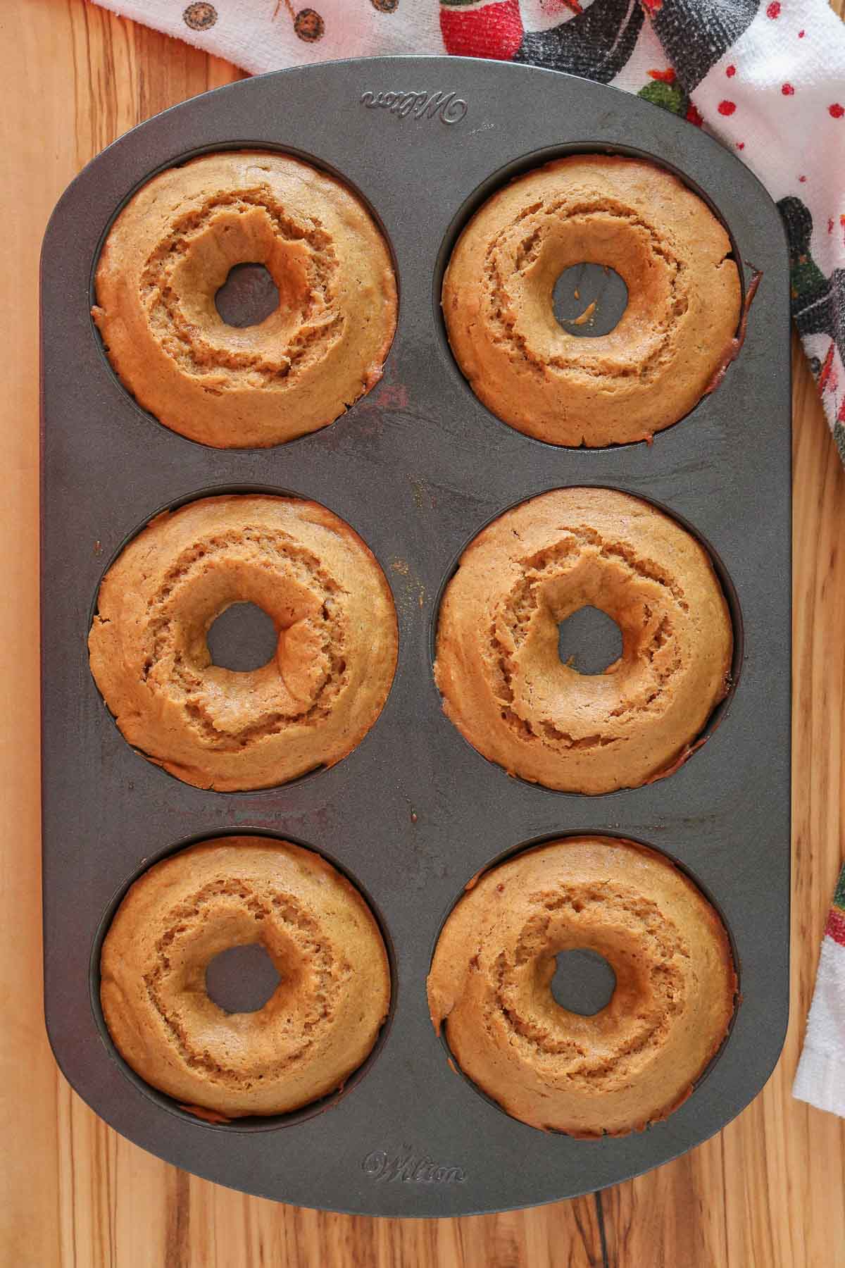 Donuts in a donut pan after being baked.