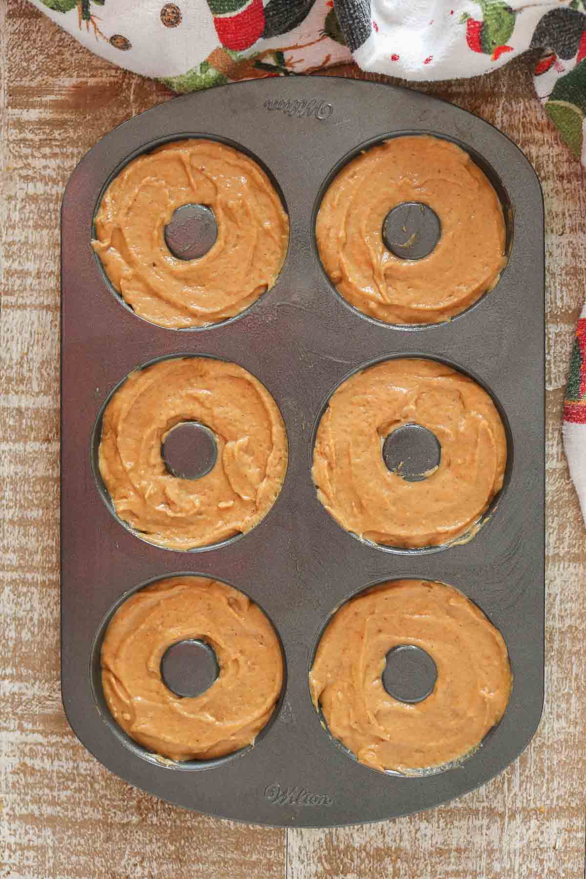 Donut batter in a donut pan before being baked.