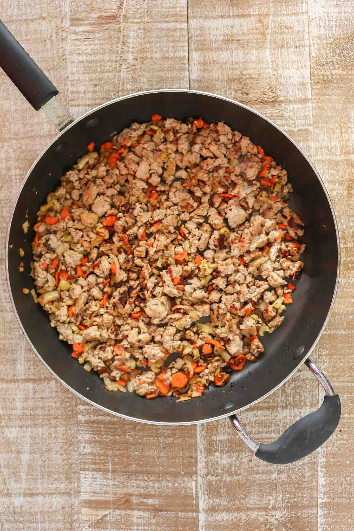 Cooked ground chicken and vegetables in a pan.