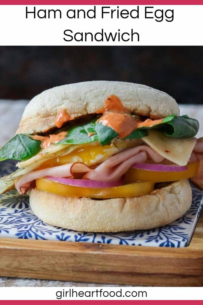 Ham and egg sandwich with cheese, baby kale, tomato, onion and harissa mayo.