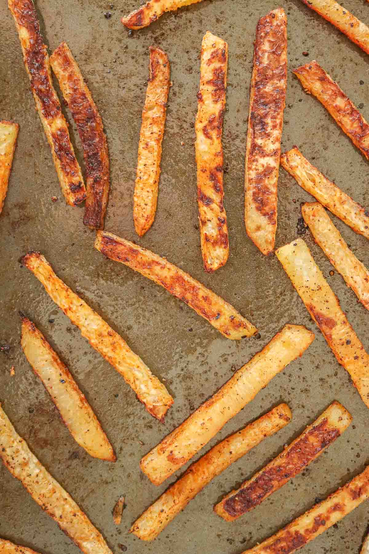 Baked kohlrabi fries on a sheet pan.