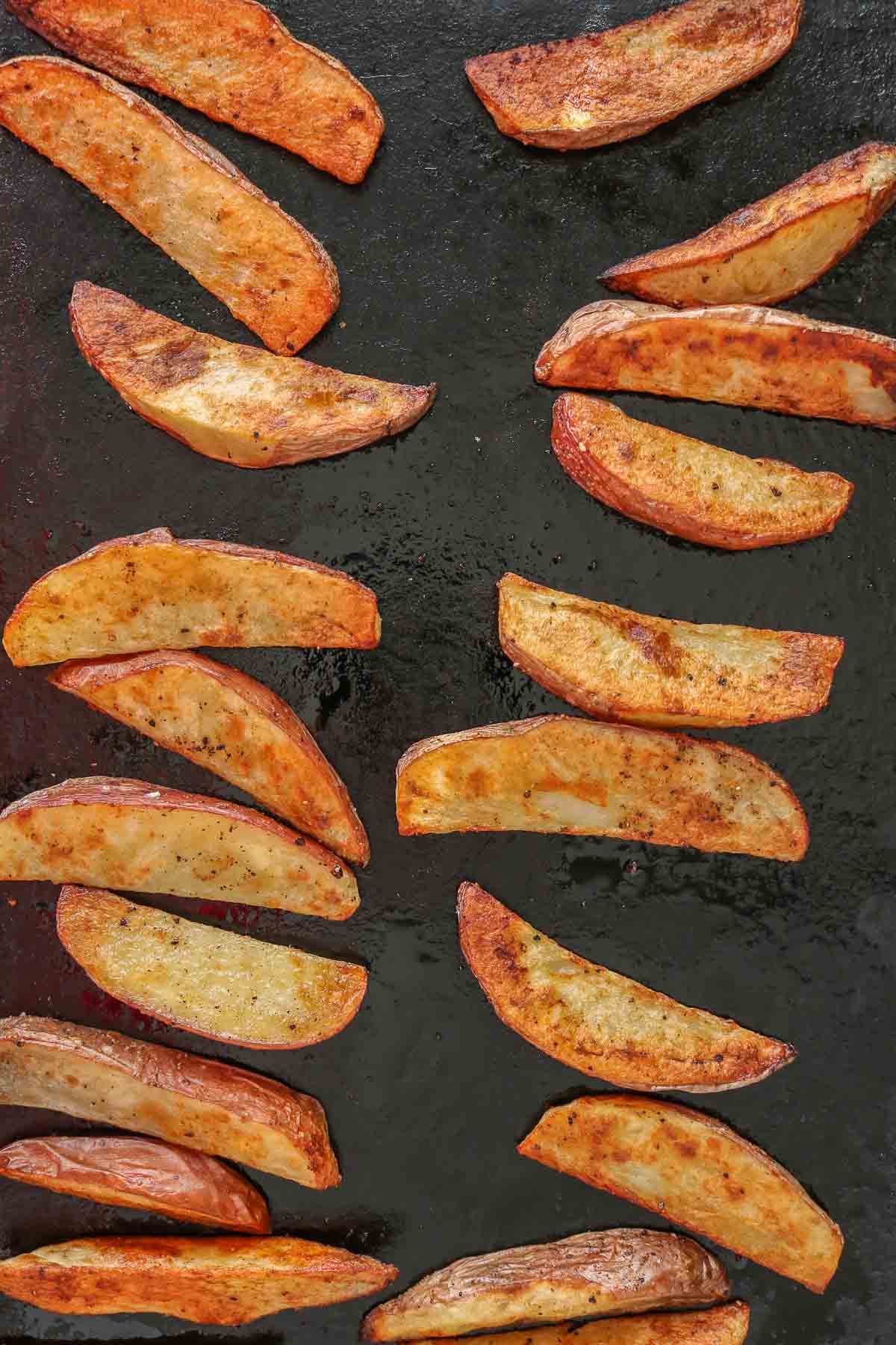 Crispy potato wedges on a sheet pan.