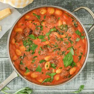 Pan of gnocchi and meatballs in creamy tomato sauce.
