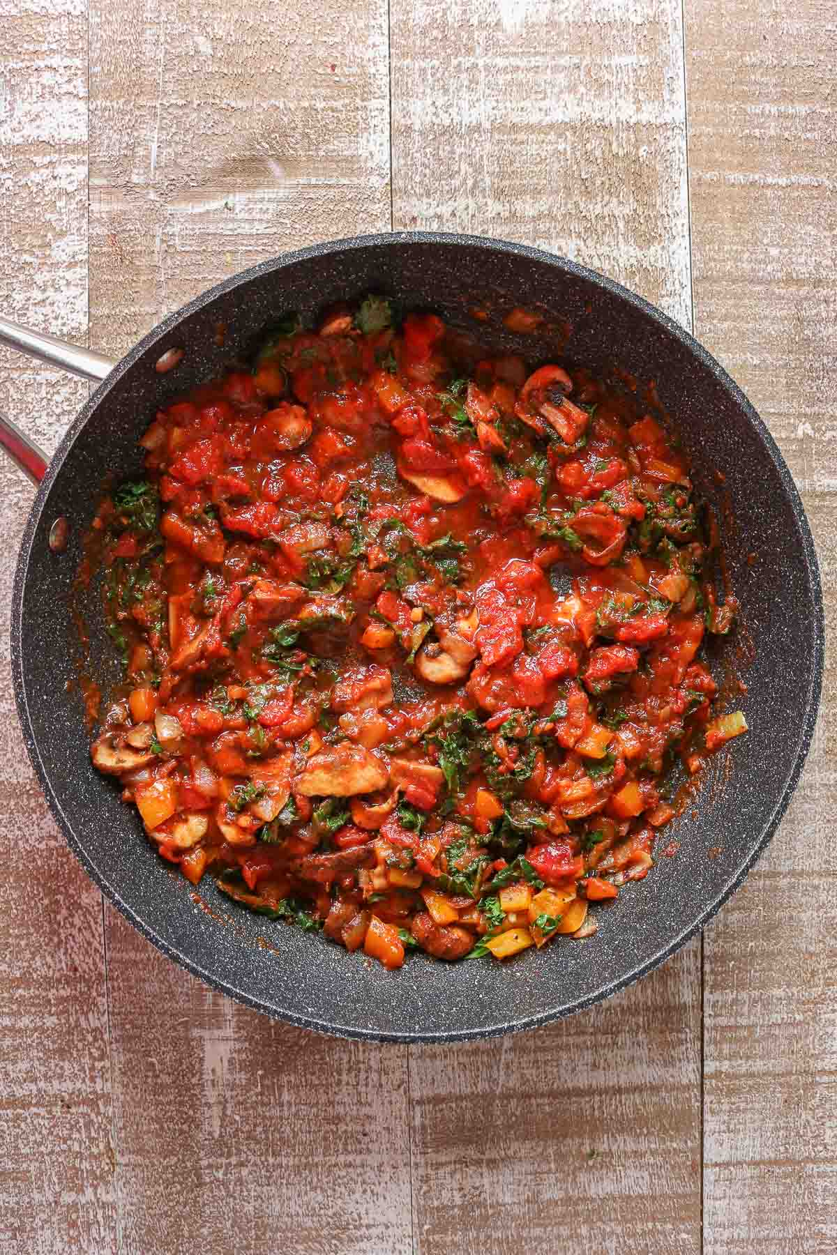 Vegetables and pasta sauce in a frying pan.