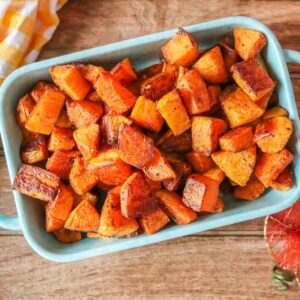 Cubes of roasted butternut squash in a serving dish.