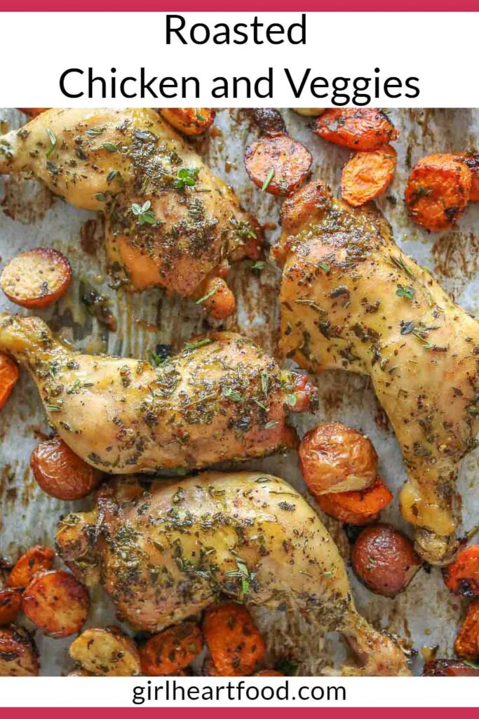 Roasted chicken legs and vegetables on a sheet pan.