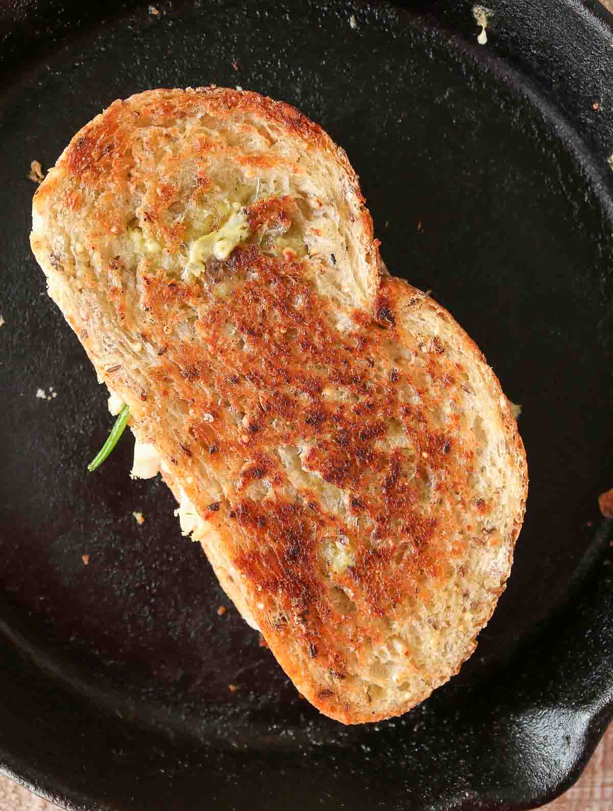 Grilled cheese sandwich in a cast-iron pan.