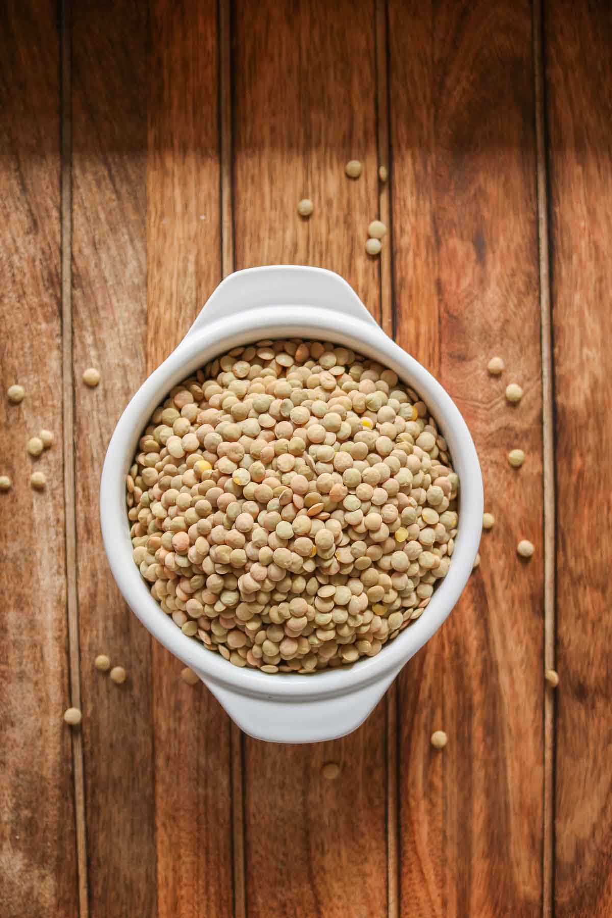 Bowl of uncooked green lentils.