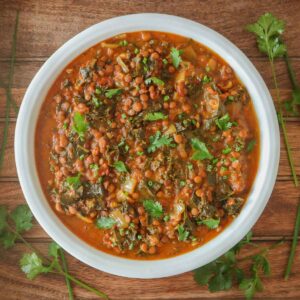 Curried lentils in a dish garnished with cilantro and chives.
