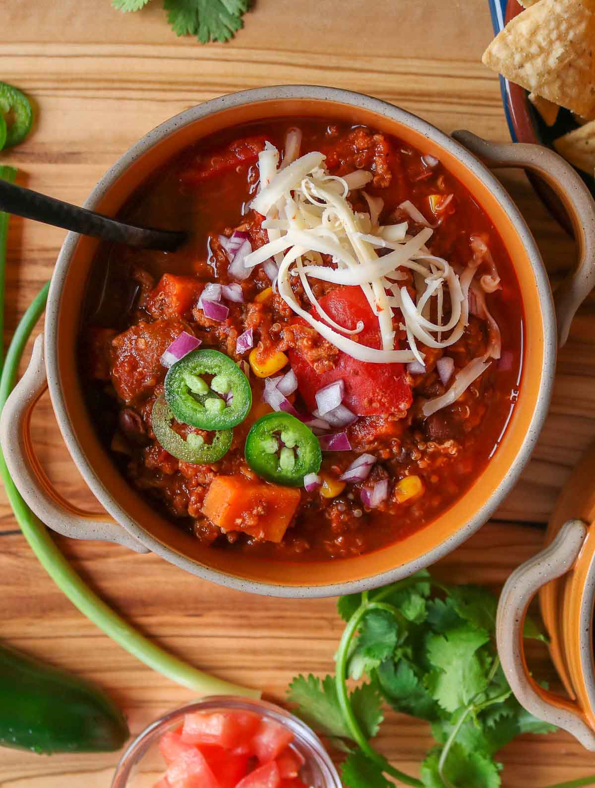 Bowl of turkey quinoa chili garnished with toppings.