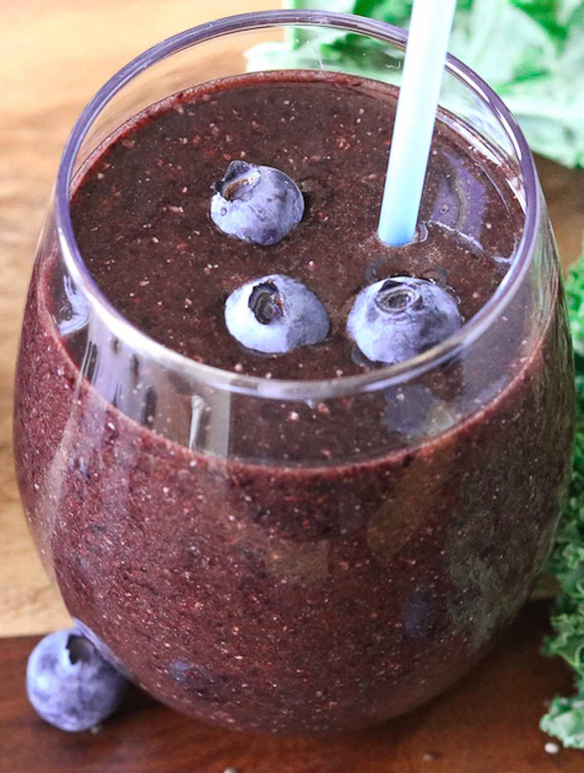 Close-up of a glass of blueberry kale smoothie.