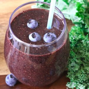 Close-up of a glass of blueberry kale smoothie.