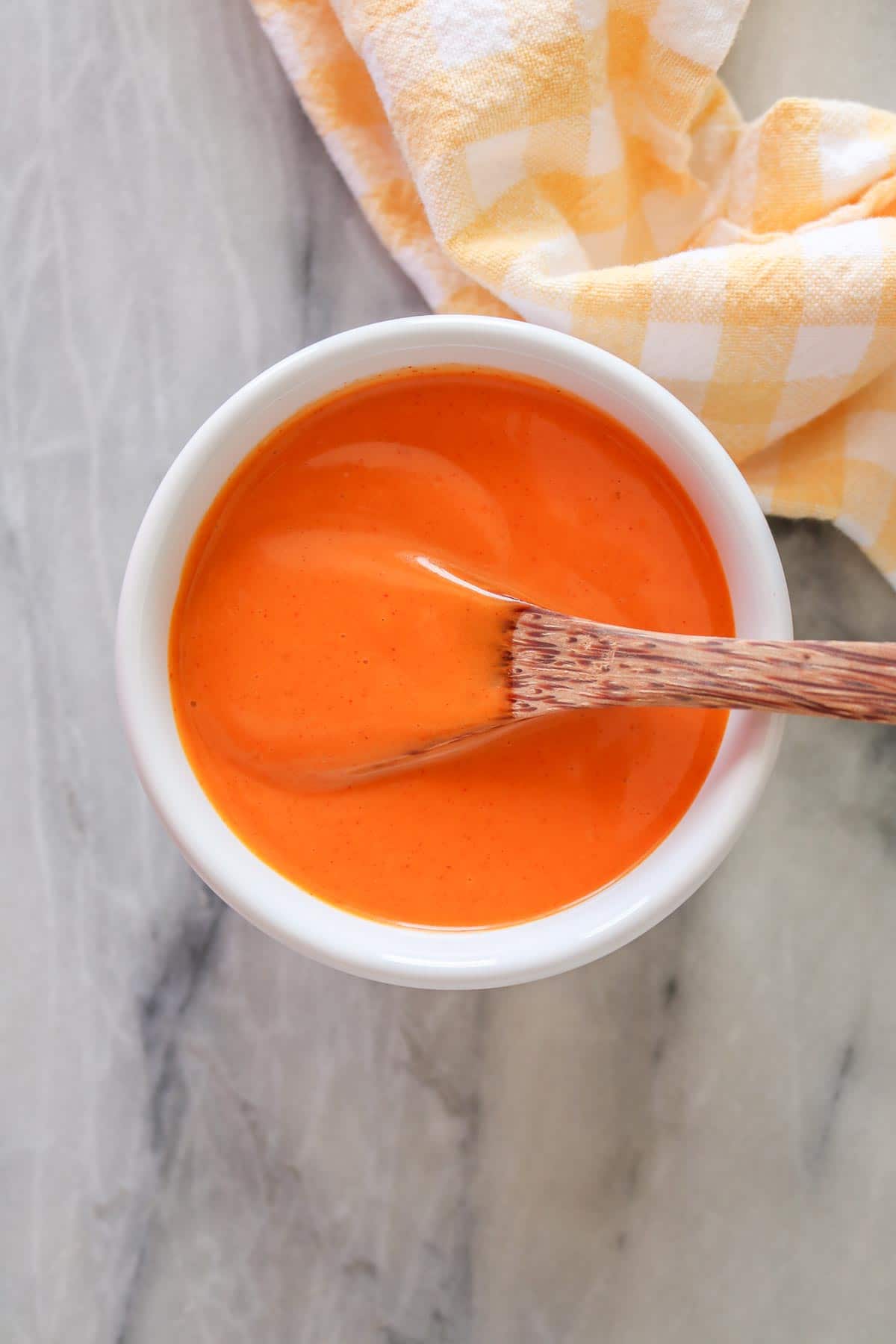 Small bowl of French dressing with a wooden spoon.