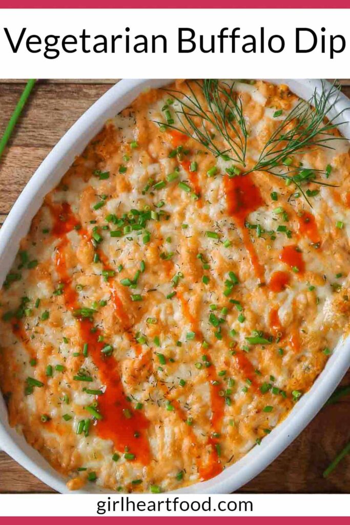 Close-up of buffalo dip in a baking dish garnished with chives, dill and buffalo sauce.