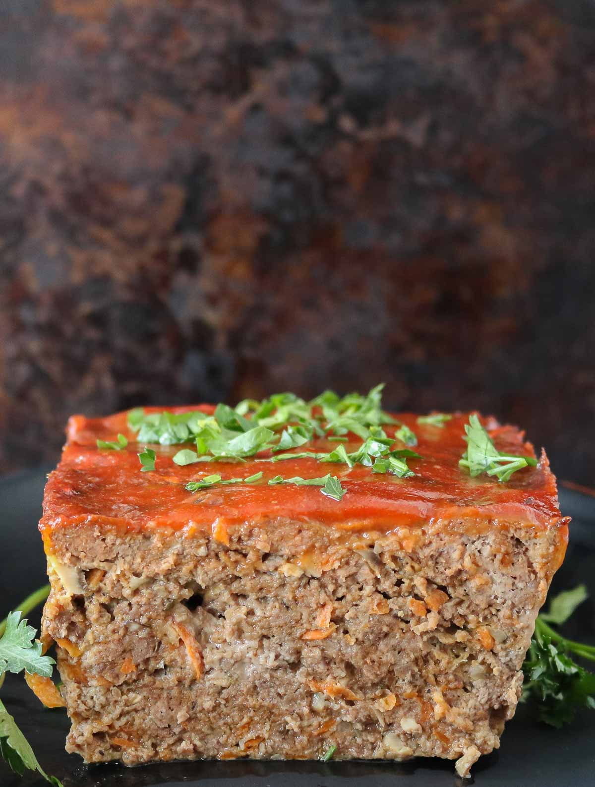 Cut meatloaf on a serving platter, showing the interior texture.