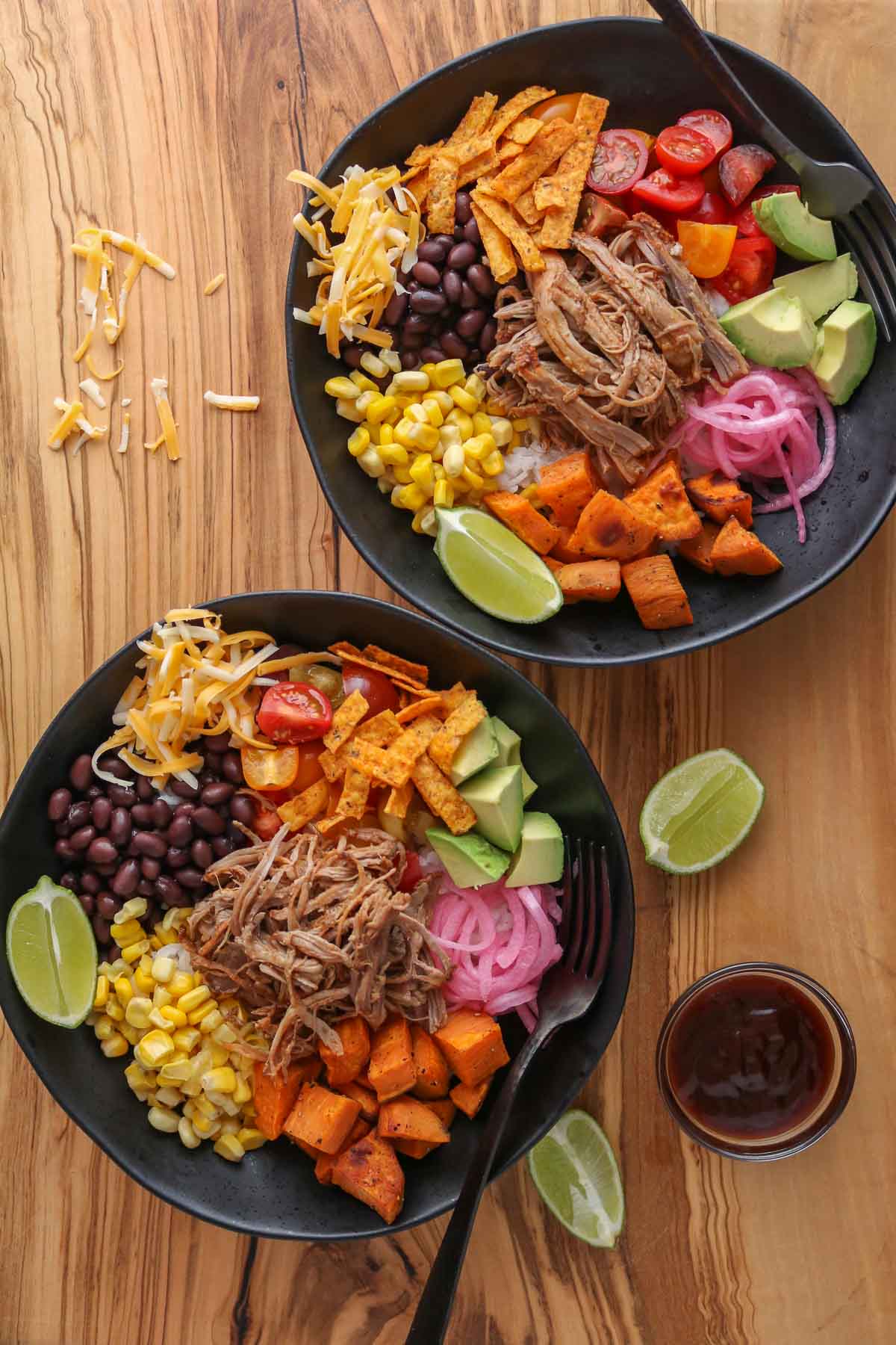 Two pulled pork rice bowls, each with toppings.