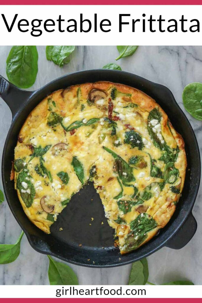 Vegetable frittata in a skillet with a piece removed.