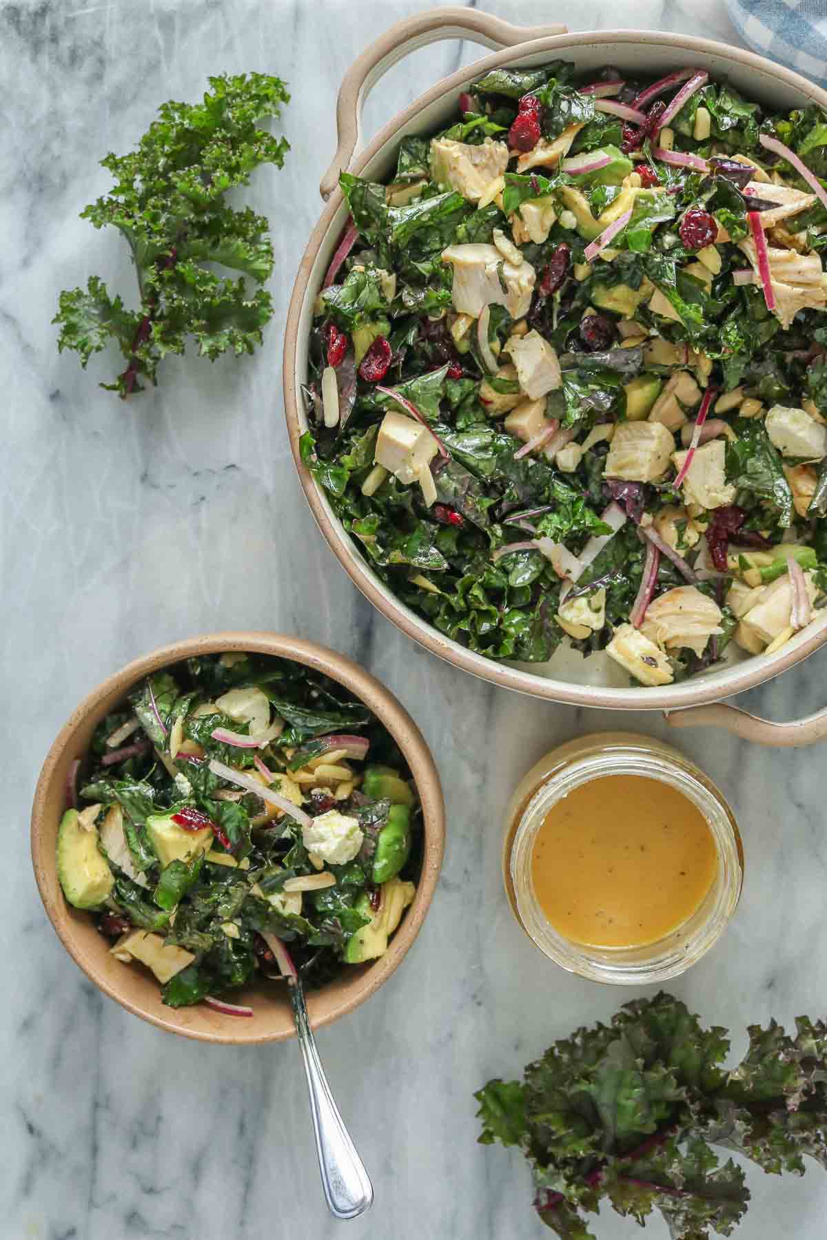 Chicken and kale salad, some in a larger bowl and some in a smaller bowl.