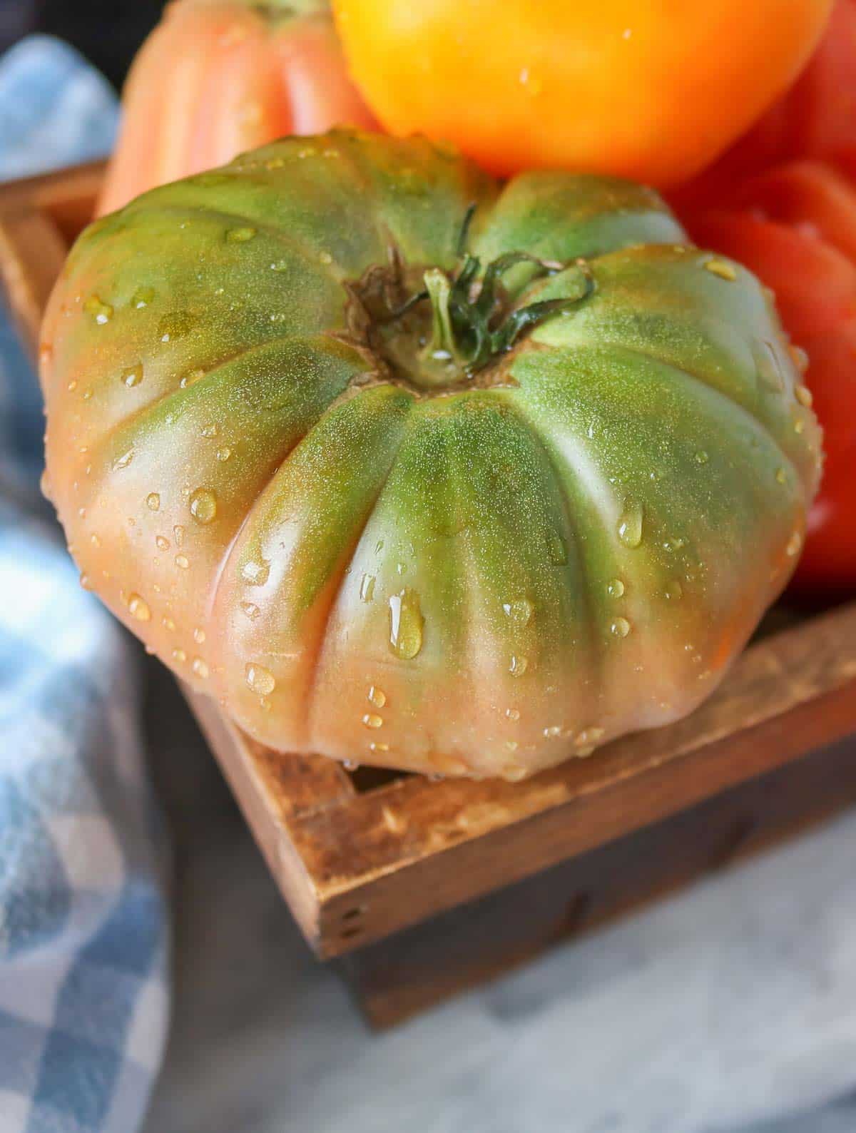 Close-up of a heirloom tomato with drops of water on it after being washed.