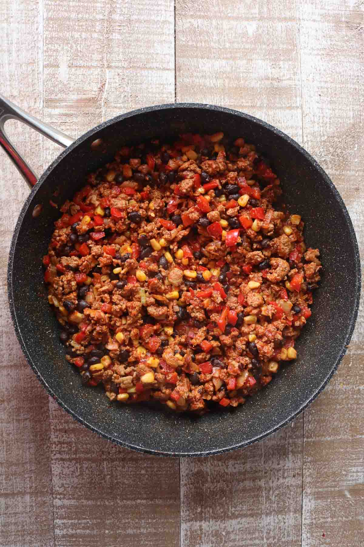 Ground turkey, bean and vegetable filling for quesadillas in a frying pan.