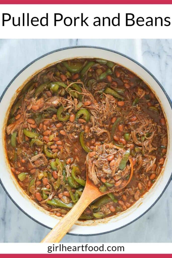 Pulled pork and beans in a pan with a serving spoon.