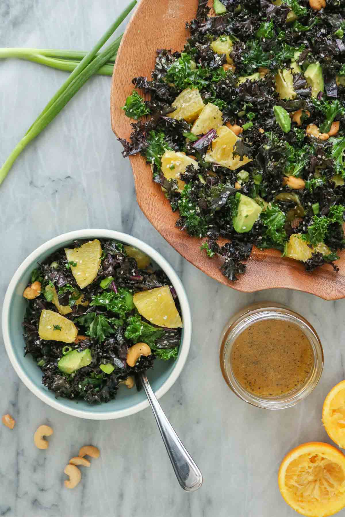 Citrus kale salad, a portion in a small bowl and some in a wooden serving bowl.