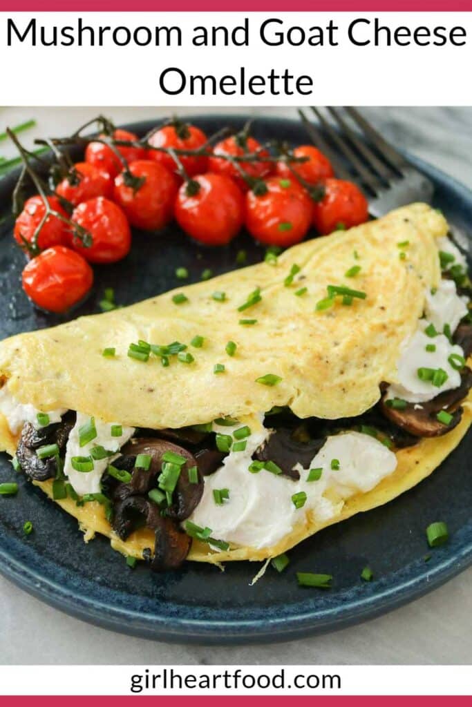 Mushroom and goat cheese omelette on a dark blue plate with roasted tomatoes.