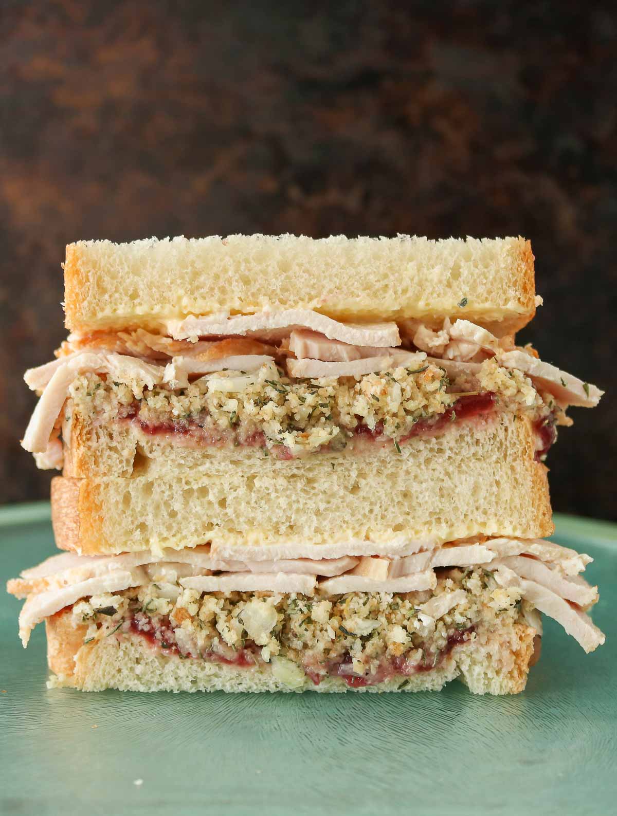 Stack of two halves of a turkey and dressing sandwich.