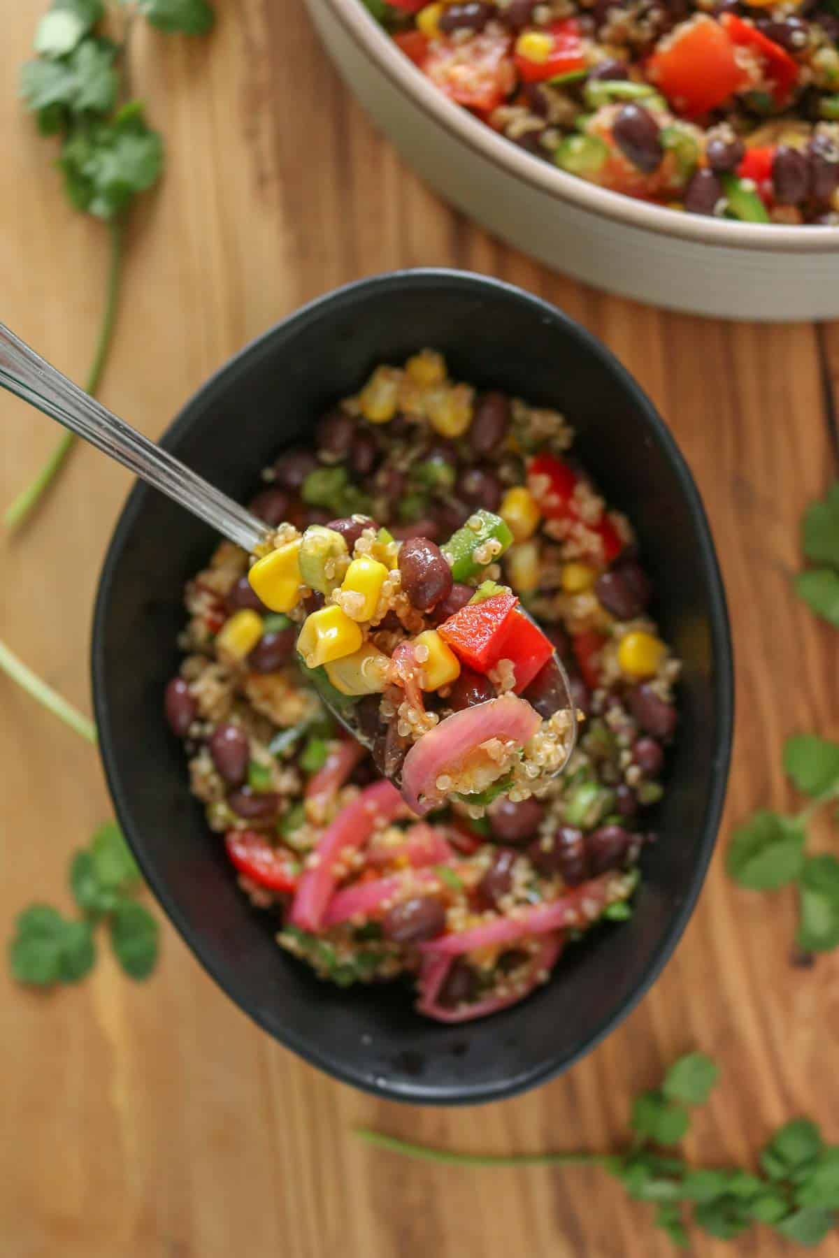 Spoonful of quinoa salad from a bowl.