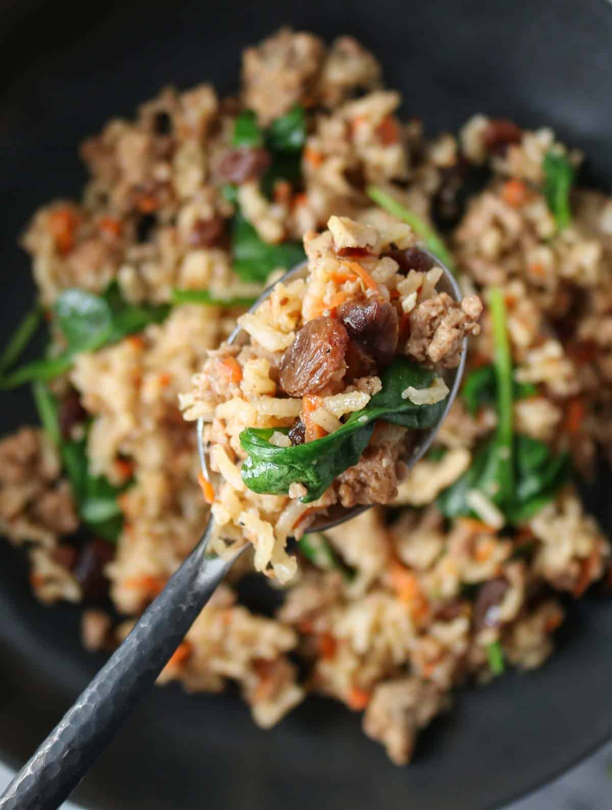 Spoonful of a ground chicken and rice skillet from a bowl.