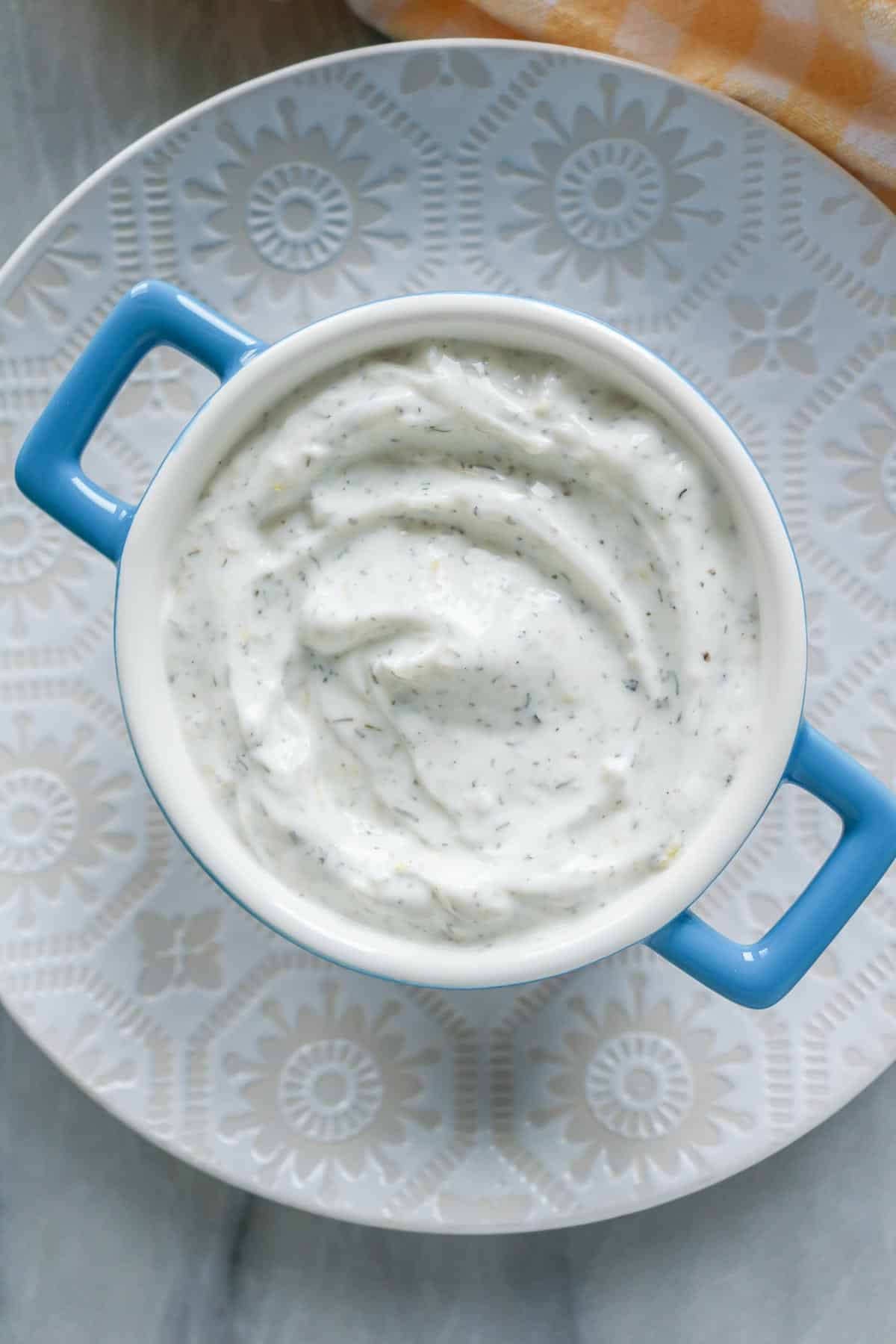 Lemon dill yogurt sauce in a serving dish.