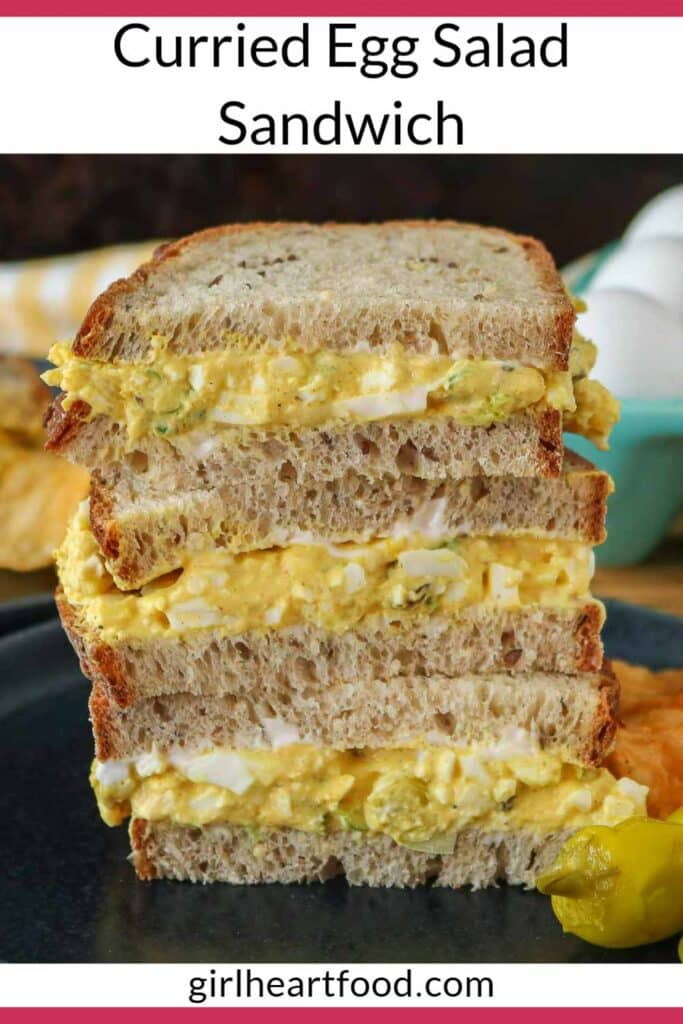 Stack of three curried egg salad sandwich halves on a plate.