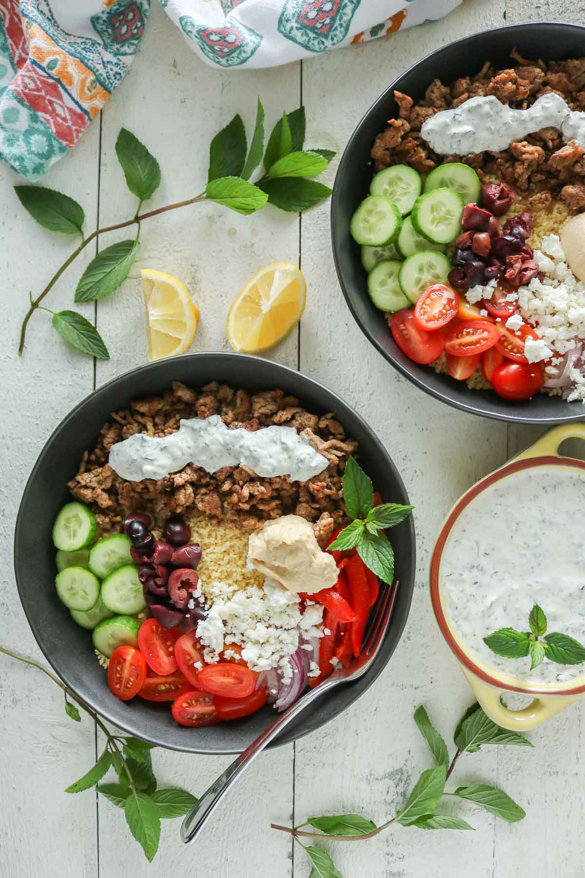 Two ground chicken and couscous bowls with toppings.