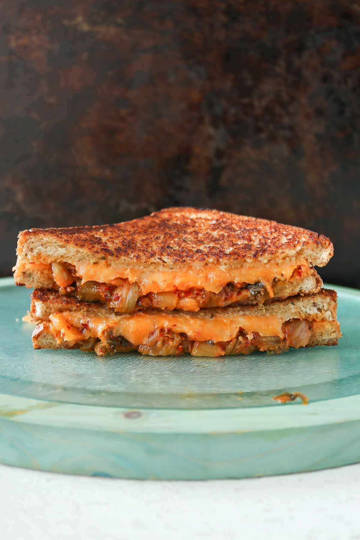 Stack of two halves of a kimchi grilled cheese sandwich.