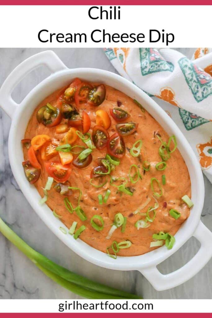 Chili cream cheese dip in a serving dish garnished with green onion and tomatoes.