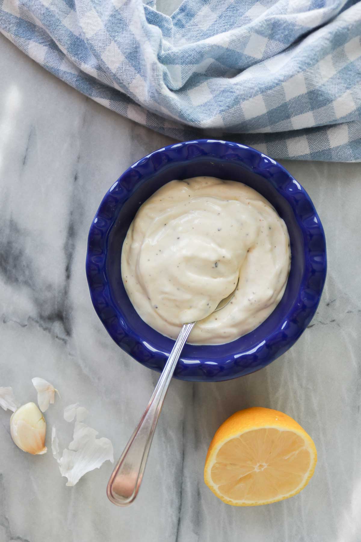 Truffle mayo in a blue serving dish with a spoon.